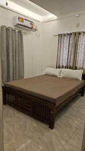 uma cama grande num quarto com cortinas em LMR Stays and Holidays em Thrissur