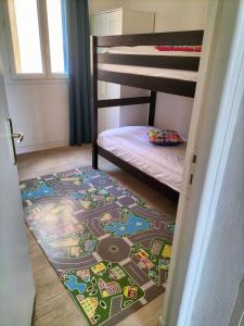 een slaapkamer met een stapelbed en een treinkleed op de vloer bij Hôtel de la Mer in Valras-Plage