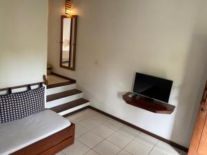 a room with a bed and a tv on a wall at Pousada Coisa e Tao in Arraial d'Ajuda