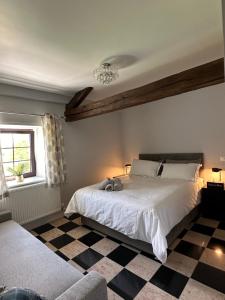 a bedroom with a bed and a checkered floor at Chambres d'hôtes du Vigeant in Le Vigeant