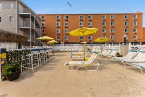 a group of chairs and umbrellas on a patio at Oceanic Hotel & Barefoot Tiki Bar in Wildwood