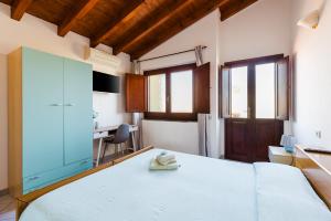 - une chambre avec un lit blanc et un bureau dans l'établissement Il Corbezzolo, à Palmas Arborea