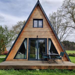 a house with a triangular roof with a table on a deck at Tipi Apache des monteaux in Vivy