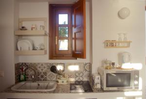 cocina con fregadero y microondas en Villa Patmos Netia - Location Xoxlakas, en Patmos