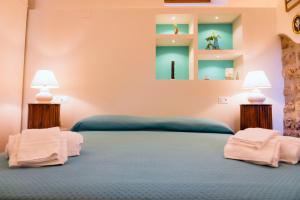 1 dormitorio con 1 cama azul y 2 lámparas en YourHome - Casa Cafiero, en Meta