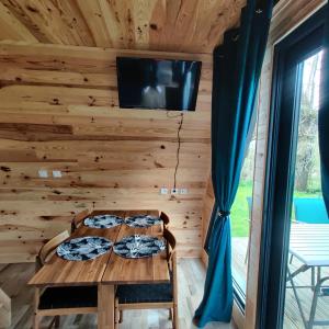 Zimmer mit einem Tisch und einem TV an der Wand in der Unterkunft Tipi Apache des monteaux in Vivy
