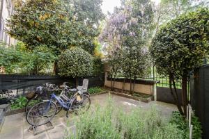 ein Fahrrad in einem Garten mit Bäumen geparkt in der Unterkunft COTTON CANDY TORTELLINOSUITE Modena in Modena