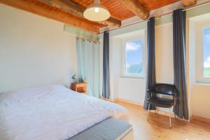 ein Schlafzimmer mit einem Bett und einem schwarzen Stuhl in der Unterkunft Maison Familiale 12 pers proche mer in Saint-Michel-en-Grève