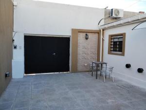 a garage with a black garage door and a table and chairs at Complejo calle Cordoba in General Roca