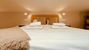 um quarto com uma cama grande com lençóis brancos e almofadas em Click&Guest - Maspalomas Serenity Villa em San Bartolomé