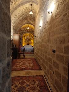 einen Flur mit einem Zimmer mit einem Bett in einem Schloss in der Unterkunft Rumet paşa konağı in Mardin