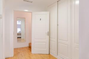 - une porte blanche dans une pièce avec un miroir dans l'établissement MAD COCO Aparts & Suites Centro Sol, à Madrid