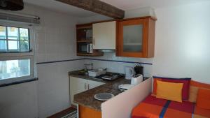 a small kitchen with a counter and a sink at Faial Adega Lemos in Horta