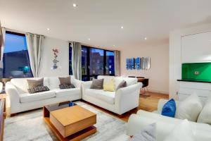 a living room with two white couches and a table at Still Life Warren Street in London
