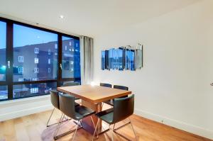 a dining room with a table and chairs and a large window at Still Life Warren Street in London