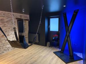 a room with two swings in a room with blue walls at La Home Love location de séduction in Folles