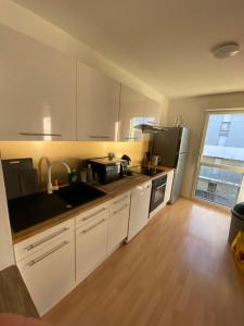 Appartement moderne T3 Cesson في سيسو سُفْيينْ: مطبخ مع دواليب بيضاء ونافذة كبيرة