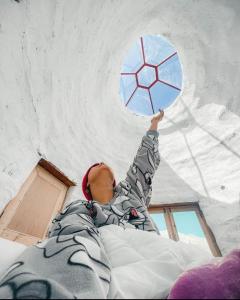 a person laying on a bed holding a blue umbrella at Spiti Eco Domes in Kaza