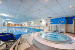a large indoor swimming pool with a large tub at Holiday Inn Edinburgh Zoo, an IHG Hotel in Edinburgh
