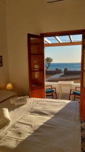 una camera con letto e vista sull'oceano di Villa Patmos Netia - Location Xoxlakas a Patmo (Patmos)