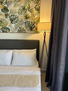 um quarto com uma cama com um quadro na parede em Modern luxury Home at The Shore by Mihome em Kota Kinabalu