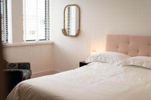 a bedroom with a white bed and a mirror at Stylish Spacious Apartment in Central Windsor in Windsor