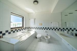 La salle de bains est pourvue d'une baignoire, de toilettes et d'un lavabo. dans l'établissement Attico sul Poetto, à Cagliari