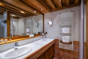 La salle de bains est pourvue de 2 lavabos et d'un grand miroir. dans l'établissement Relais et Châteaux - Les Bas-Rupts, à Gérardmer