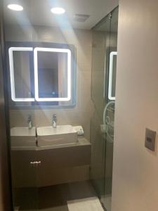 een badkamer met een wastafel en een glazen douche bij Hotel Oasis in Mexico-Stad