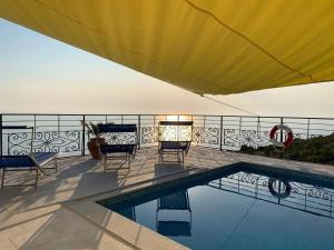 eine Terrasse mit Stühlen und einem Pool in der Unterkunft 3 bedrooms villa at Zagora 40 m away from the beach with sea view private pool and furnished terrace in Zagora