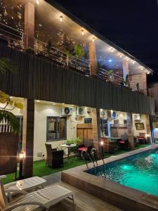 a house with a swimming pool at night at Dodo's Garden in Cotonou