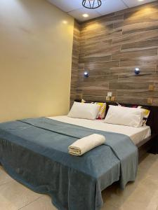 a bedroom with a large bed with a blue blanket at Dodo's Garden in Cotonou