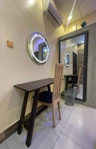 a dining room with a wooden table and a mirror at Dodo's Garden in Cotonou