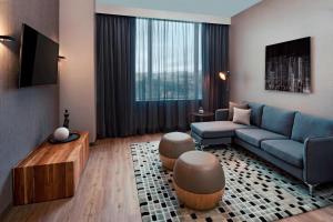 a living room with a blue couch and a tv at AC Hotel by Marriott San Jose Escazu in San José