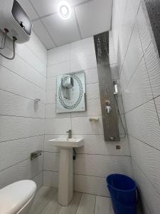 a white bathroom with a sink and a mirror at Dodo's Garden in Cotonou +40 photos