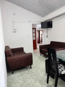 a living room with two chairs and a couch and a tv at Hotel Villasaurio in Sáchica