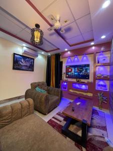a living room with a couch and a tv at Dodo's Garden in Cotonou