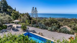 a house with a swimming pool and the ocean at Campo Agave Luxury Tents in Sayalonga