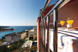 two wine glasses sitting on the balcony of a building at Apartments Martina 2 in Primošten