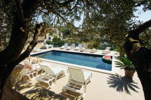 a swimming pool with lounge chairs and a swimming pool at Apartments Martina 2 in Primošten