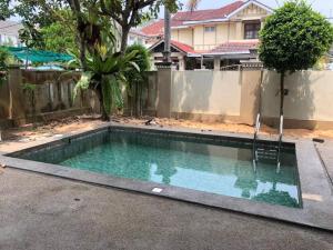 a swimming pool in front of a fence at Omar Little Palace - 10 Bedroom Homestay Seremban in Seremban