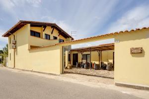 a yellow house with a patio in front of it at Il Corbezzolo Apartment in Palmas Arborea