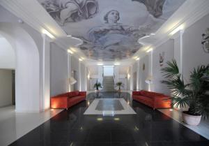 a lobby with red couches and a painting on the ceiling at Chateau Herálec Boutique Hotel & Spa by L'Occitane in Herálec