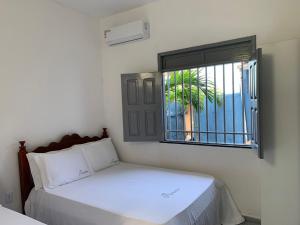 a bedroom with a bed and a window at Recanto do Porto _ Hospedagem in Cayru