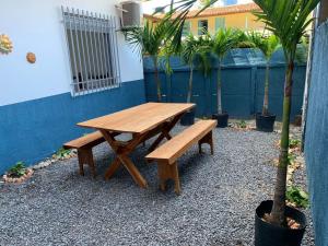 a wooden picnic table and bench in a courtyard at Recanto do Porto _ Hospedagem in Cayru