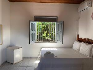 a bedroom with a large bed and a window at Recanto do Porto _ Hospedagem in Cayru