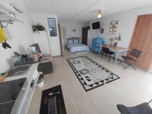 a kitchen and living room with a sink and a table at T2 avec Piscine exclusive in Bourg-Saint-Bernard
