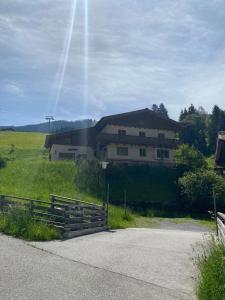 a house with a fence in front of a field at Haus Pistenblick in Dienten am Hochkönig