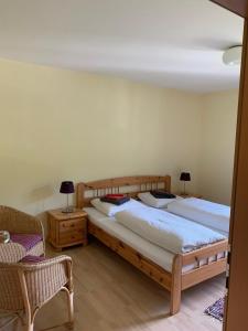 two beds in a bedroom with a chair and a couch at Haus Pistenblick in Dienten am Hochkönig