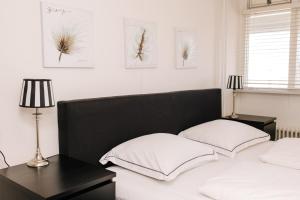 a bedroom with two beds with white pillows and two lamps at Appartement Babette in Zandvoort